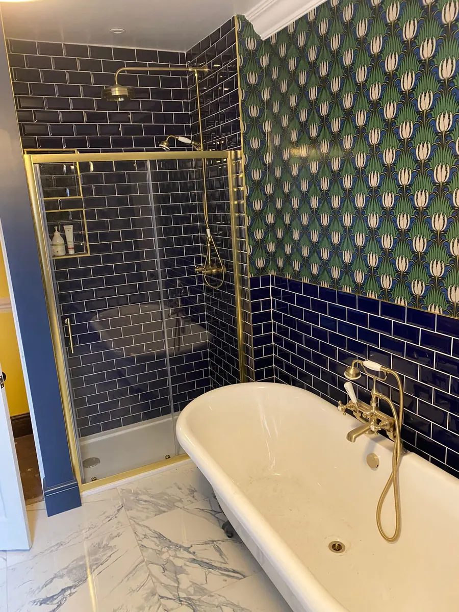 Completed bathroom with brass fittings and navy tile by J Matthews Plumbing and Gas
